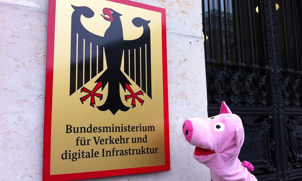 Am nächsten Tag hat es sich wieder beruhigt und geht spazieren. Vor der Türe eines Ministeriums kommt das Schwein auf eine Idee.