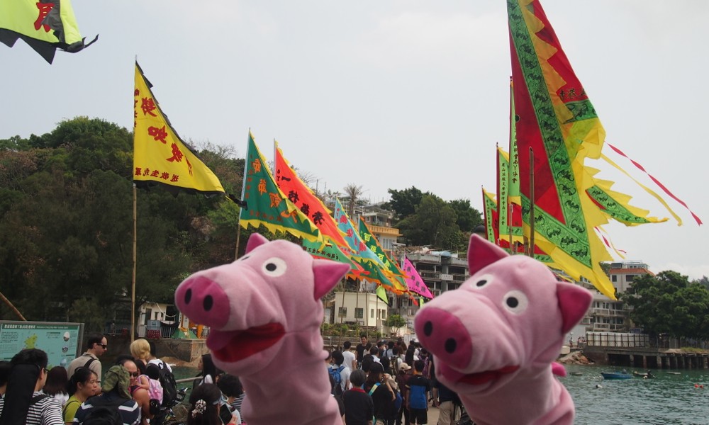 Am nächsten Tag machen sie einen Ausflug nach Lamma Island, wo für die Schweine geschmückt wurde.